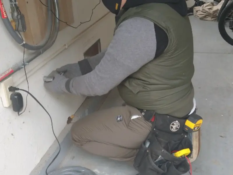 Electrician performing outlet wiring in a Greenport garage